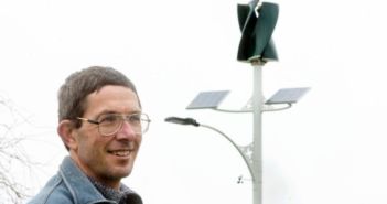 Chris Teo-Sherrell with the recently erected solar and wind powered street light